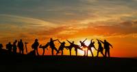 Gruppe springt im Gegenlicht der Sonne nach oben